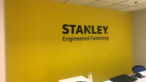 ป้าย STANLEY บนผนังสีเหลือง