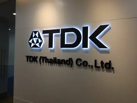 ป้ายตัวอักษรไฟออกหลัง TDK บนผนังสำนักงาน
