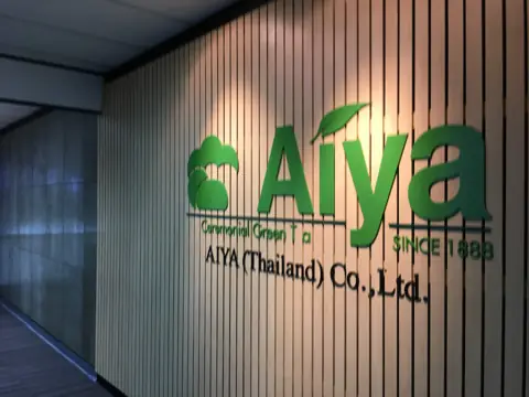 ป้ายตัวอักษรสีเขียว Aiya บนผนังไม้