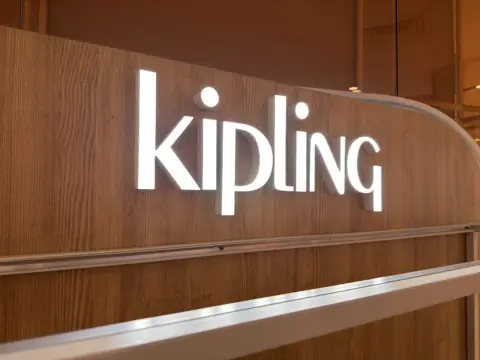 ตัวอักษรไฟ KIPLING บนแผงไม้