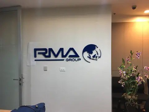 โลโก้ RMA GROUP บนผนังสำนักงาน