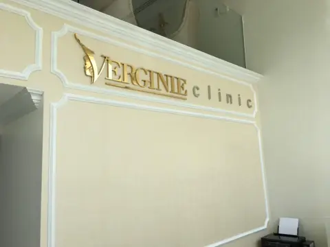 ตัวอักษรโลหะสีทอง VERGINIE บนแผงตกแต่ง