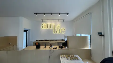 ตัวอักษรสีทอง am tea บริเวณเคาน์เตอร์ร้าน