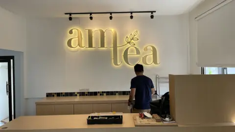 มุมกว้างป้าย am tea และพื้นที่เคาน์เตอร์