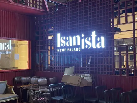 ป้ายไฟ Isanista บนผนังโครงเหล็กสีแดง