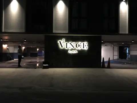 ป้ายตัวอักษรไฟ VINCE บนหน้าอาคารยามค่ำ