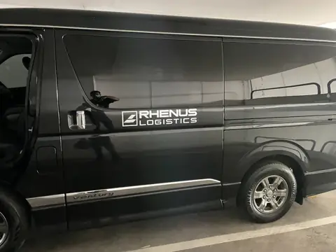 กราฟิกโลโก้ RHENUS LOGISTICS บนรถตู้สีดำ