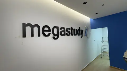 ป้าย megastudy บนผนังขาวและน้ำเงิน
