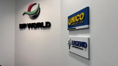 ป้าย DP WORLD และป้ายบริษัทบนผนัง