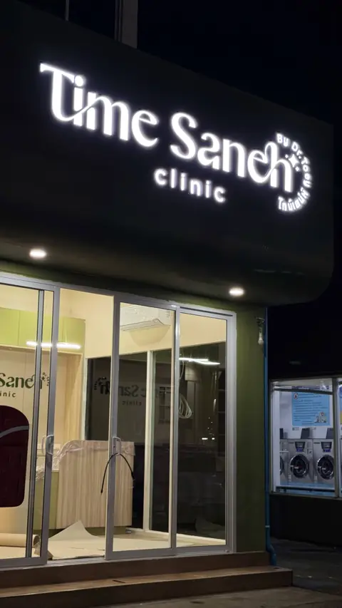 ป้ายไฟ Time Sancti Clinic หน้าร้านยามค่ำ
