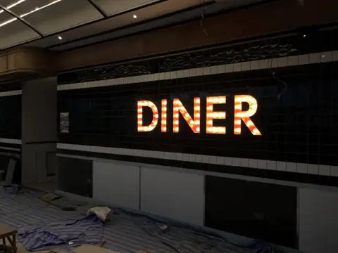 ป้าย DINER ตัวอักษรไฟสีอุ่นบนตะแกรง